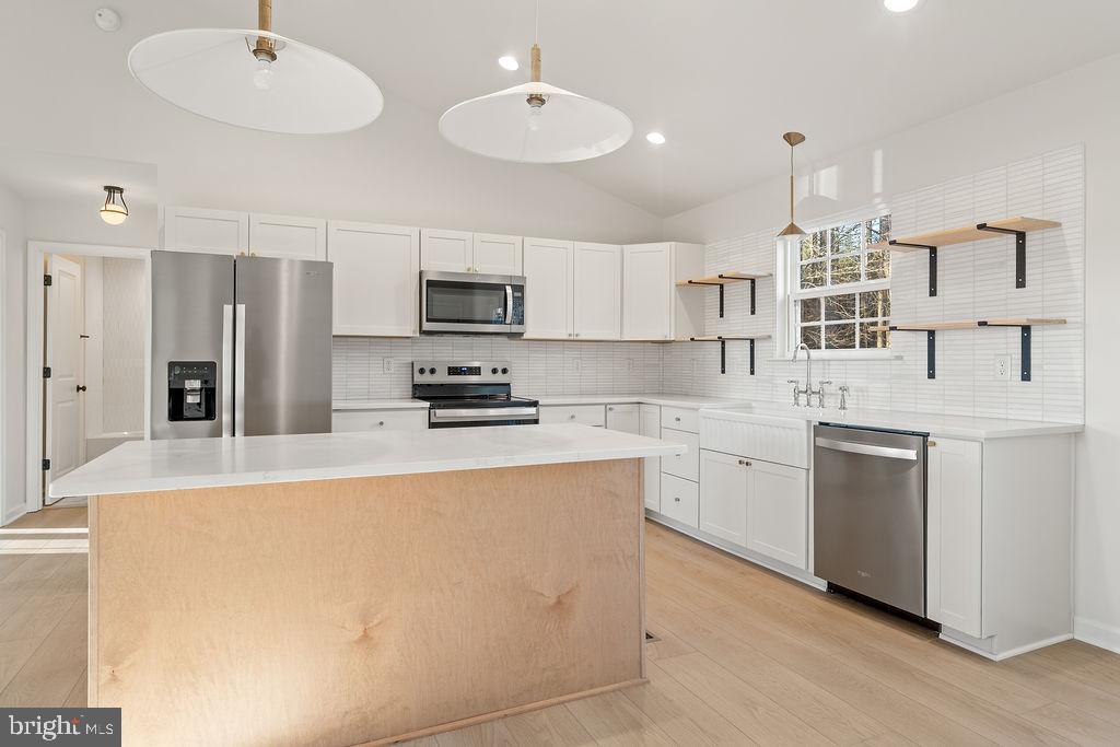 2770 Fredericks Hall Road Mineral, VA 23117 - Photo 16 of 57 a kitchen with kitchen island a sink stainless steel appliances and white cabinets