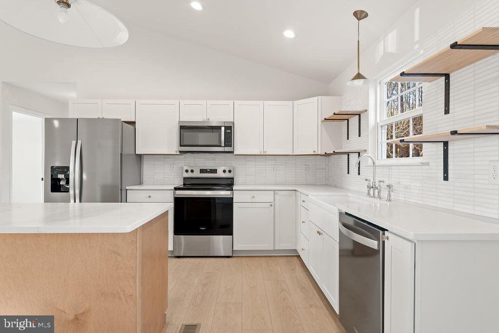 2770 Fredericks Hall Road Mineral, VA 23117 - Photo 18 of 57 a kitchen with kitchen island a sink stainless steel appliances and cabinets
