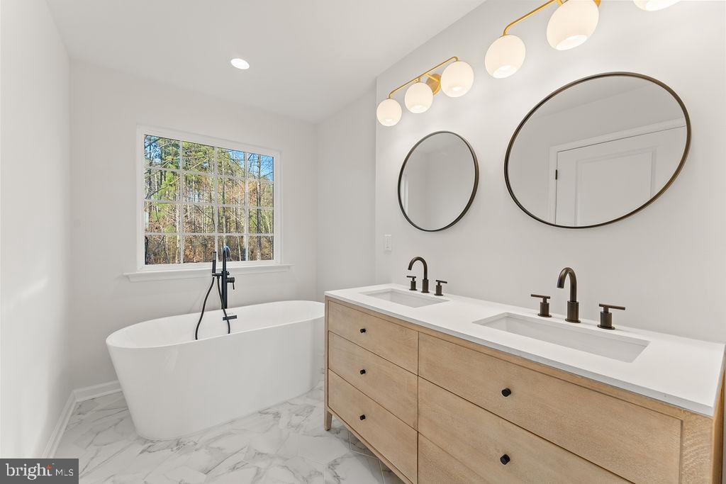 2770 Fredericks Hall Road Mineral, VA 23117 - Photo 25 of 57 a bathroom with a tub a double vanity sink and a window