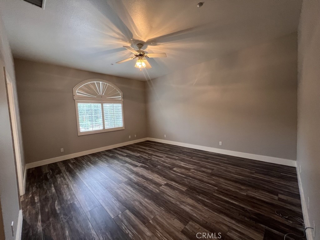 8715 Dufferin Avenue Riverside, CA 92504 - Photo 15 of 27 an empty room with wooden floor fan and windows