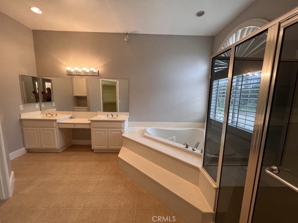 8715 Dufferin Avenue Riverside, CA 92504 - Photo 7 of 27 a bathroom with a double vanity sink a mirror and a bathtub