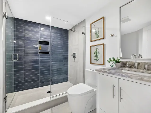 a bathroom with a sink a toilet and shower