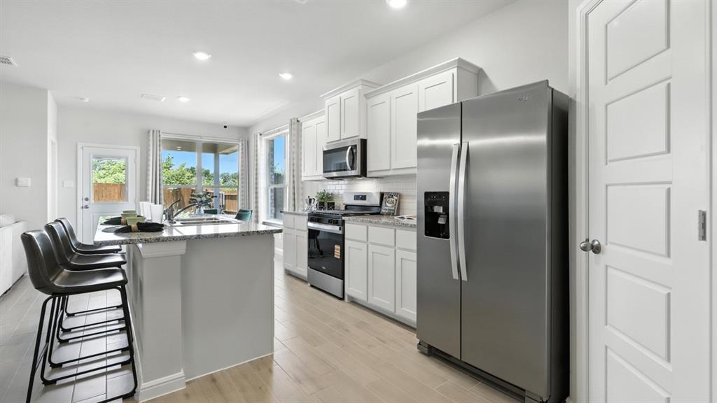a kitchen with refrigerator and chairs