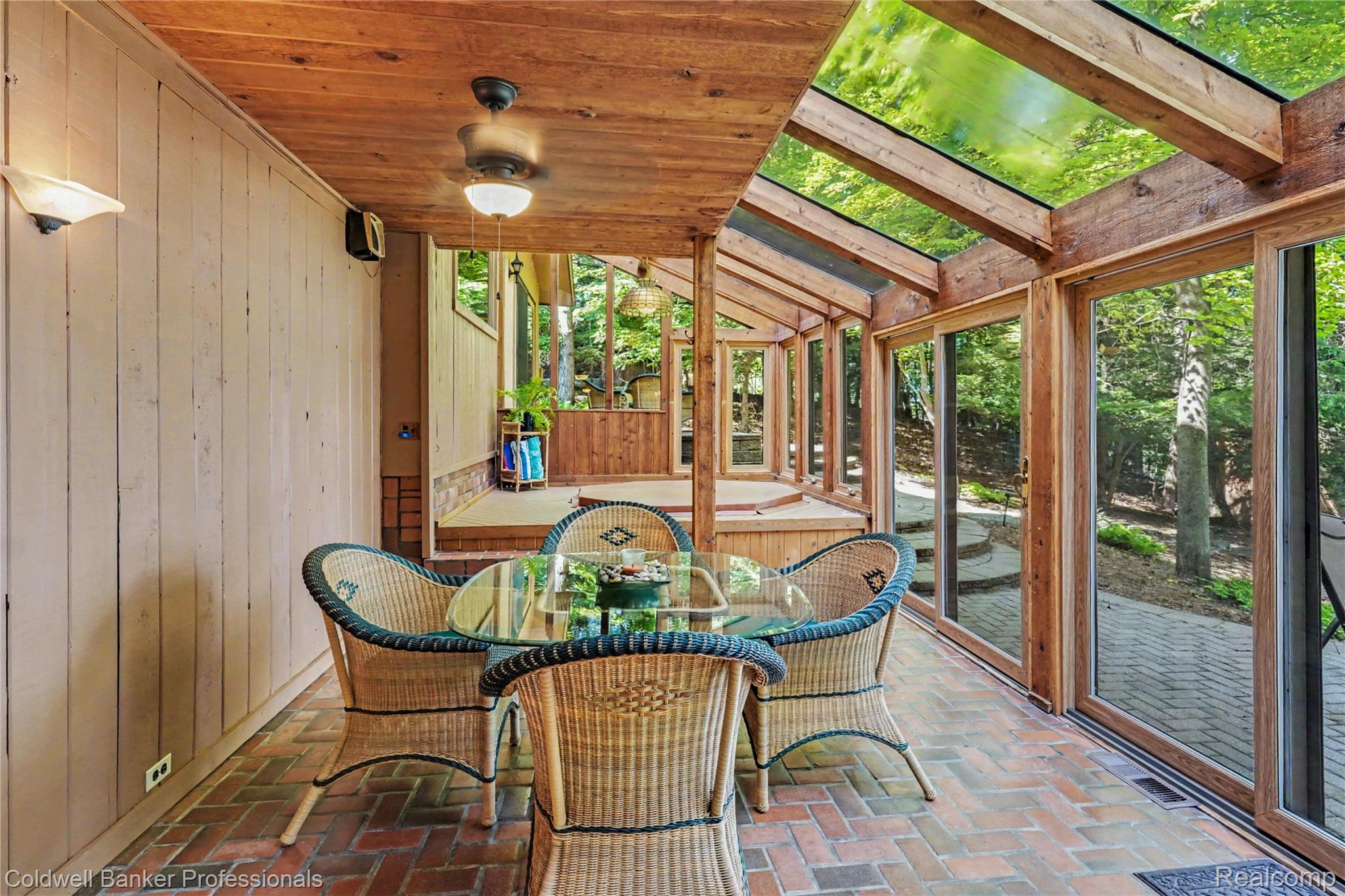 3583 Mitchell Road Metamora, MI 48455 - Photo 24 of 58 Enclosed porch featuring a brick-finish flooring, wood-paneled ceiling with a ceiling fan, and extensive glass paneling with wood framing