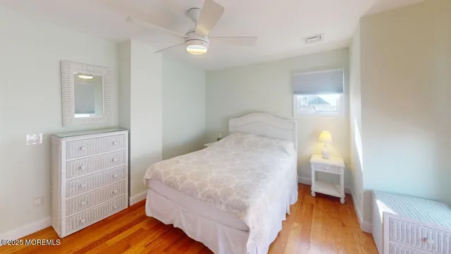 a bedroom with a bed and a lamp on dresser