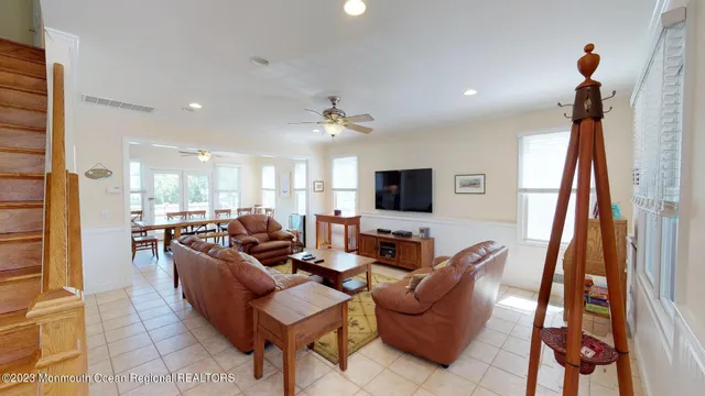 a living room with furniture a flat screen tv and a large window