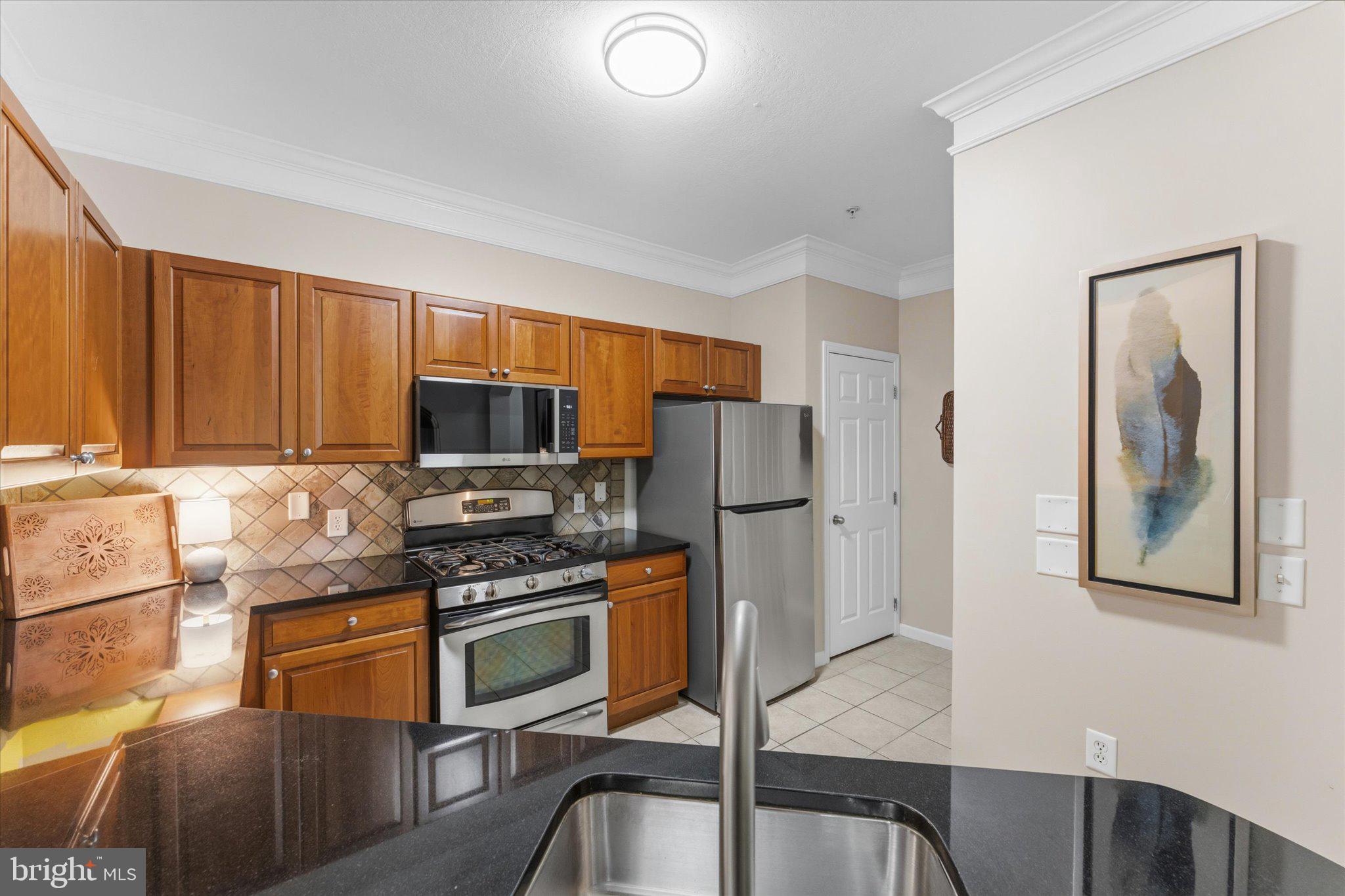 503 Sunset View Terrace Southeast, Unit 101 Leesburg, VA 20175 - Photo 5 of 39 Modern kitchen with warm wood tones.