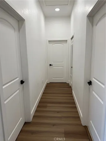 a view of a hallway with wooden floor and staircase
