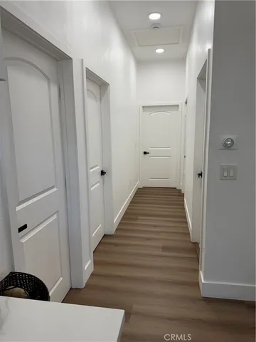 a view of a hallway with wooden floor and staircase