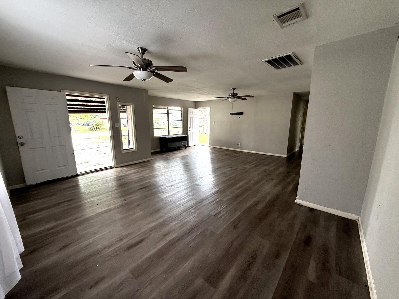 10341 Caxton Street Houston, TX 77016 - Photo 6 of 17 Open living area with modern flooring and ceiling fan.