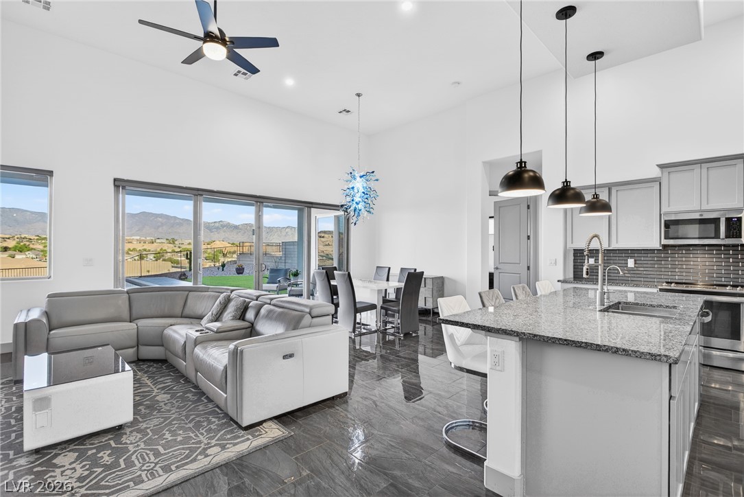 1460 Blue Ridge Trail Mesquite, NV 89027 - Photo 11 of 39 Natural light floods this inviting living space, offering picturesque mountain views through a wall of sliding glass doors.
