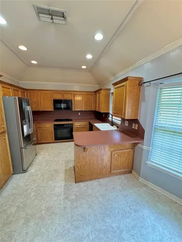 a living room with stainless steel appliances furniture a rug and a window