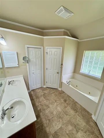 a bathroom with a tub sink and mirror