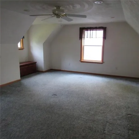 an empty room with windows and ceiling fan