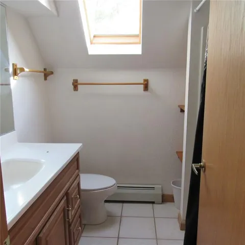 a bathroom with a sink a toilet and a window