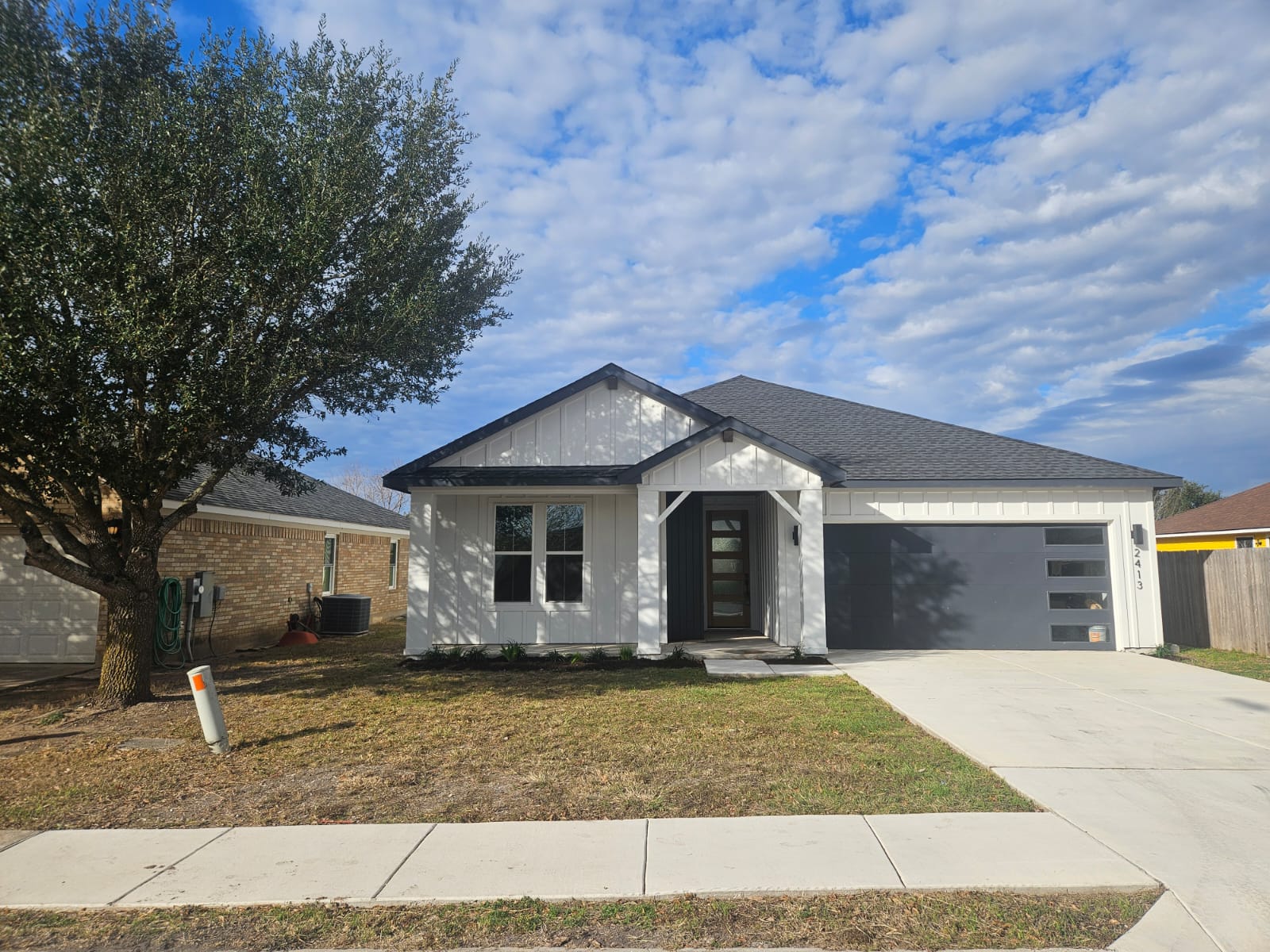 View of front of home featuring concrete driveway, a garage, board and batten siding, and a shingled roof