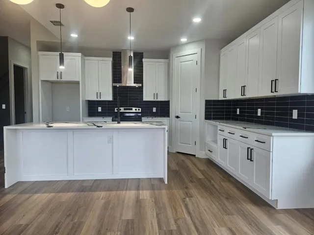 a kitchen with a sink white cabinets and stainless steel appliances