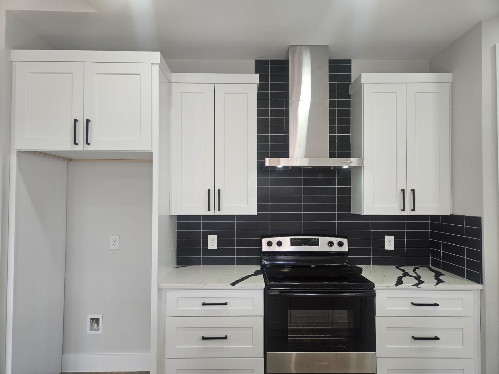 2413 Blue Sky Lane Lockhart, TX 78644 - Photo 11 of 39 Kitchen featuring stainless steel electric range, wall chimney range hood, light stone counters, white cabinetry, and decorative backsplash