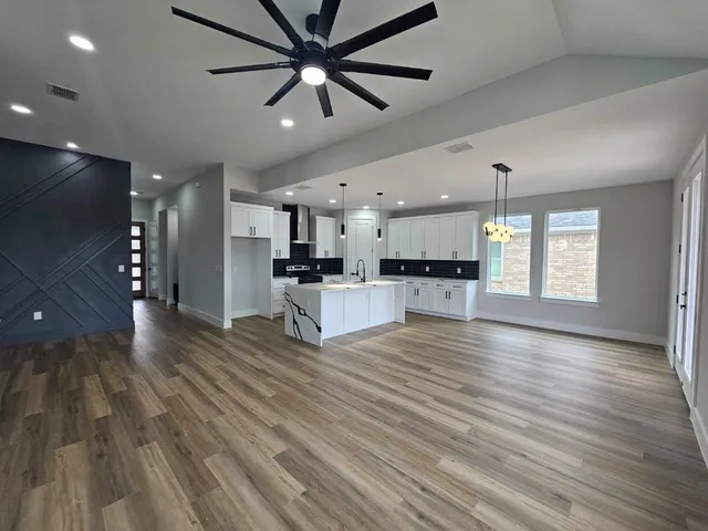 a view of white cabinets with wooden floor