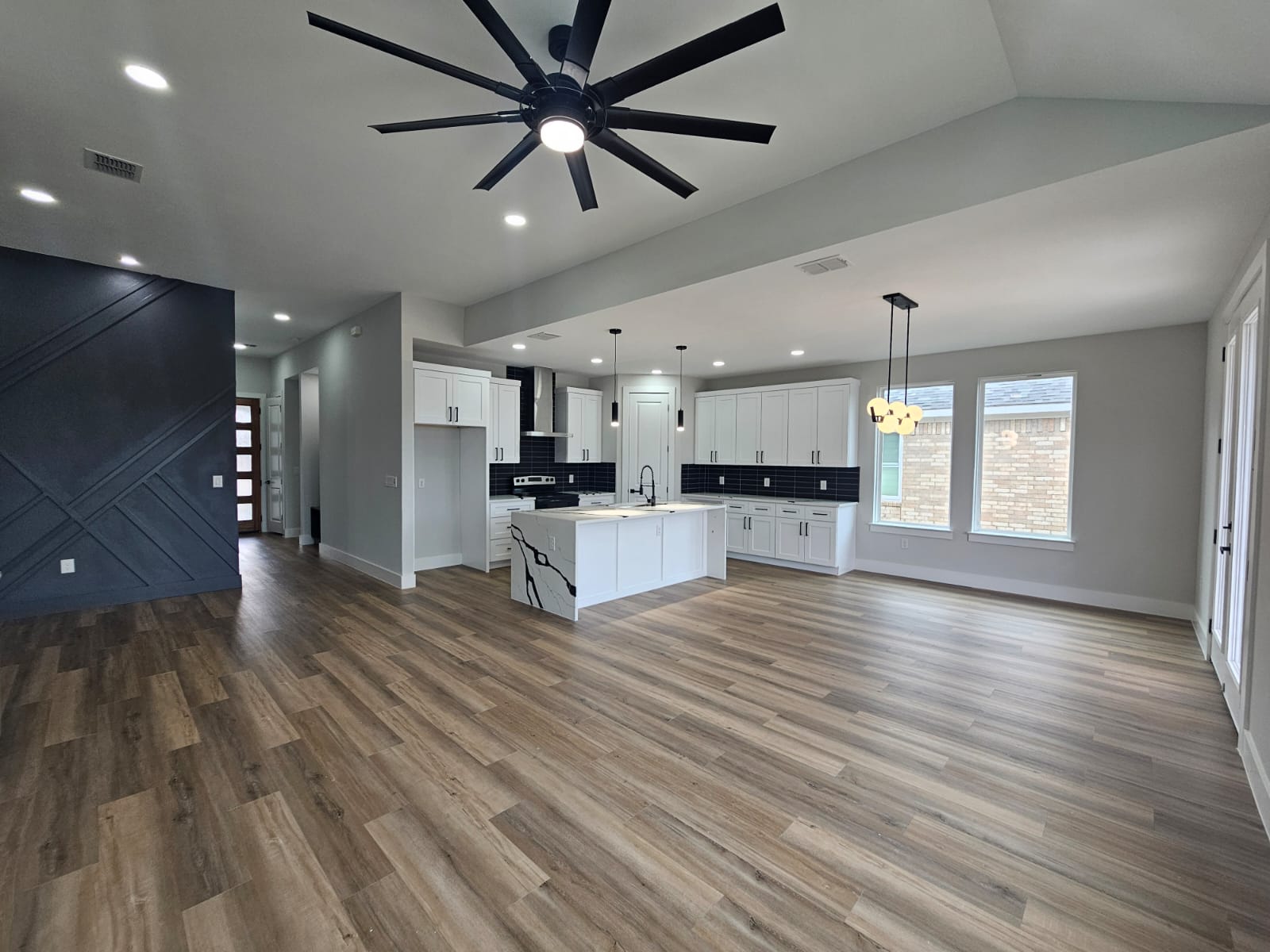2413 Blue Sky Lane Lockhart, TX 78644 - Photo 13 of 39 Unfurnished living room with ceiling fan, light wood-type flooring, recessed lighting, and a chandelier
