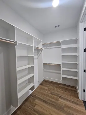 a view of a big room with wooden floor and a ceiling fan