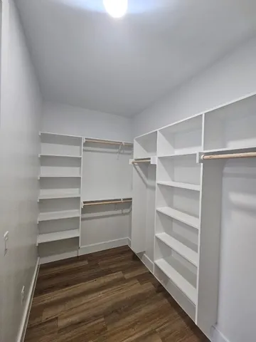 a view of walk in closet with empty racks