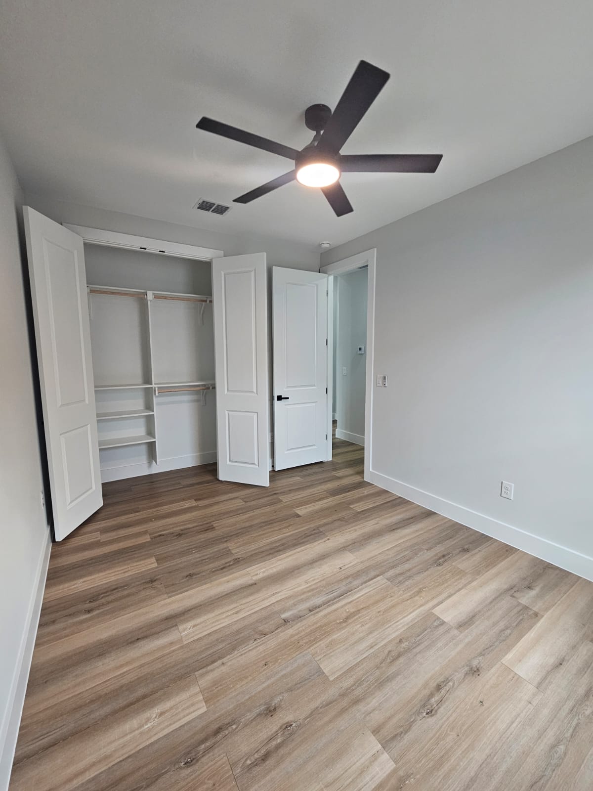 2413 Blue Sky Lane Lockhart, TX 78644 - Photo 28 of 39 Unfurnished bedroom featuring ceiling fan, light wood finished floors, and a closet