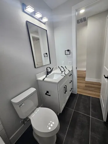 a bathroom with a toilet sink and mirror