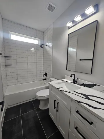 a bathroom with a double vanity sink toilet mirror and bathtub