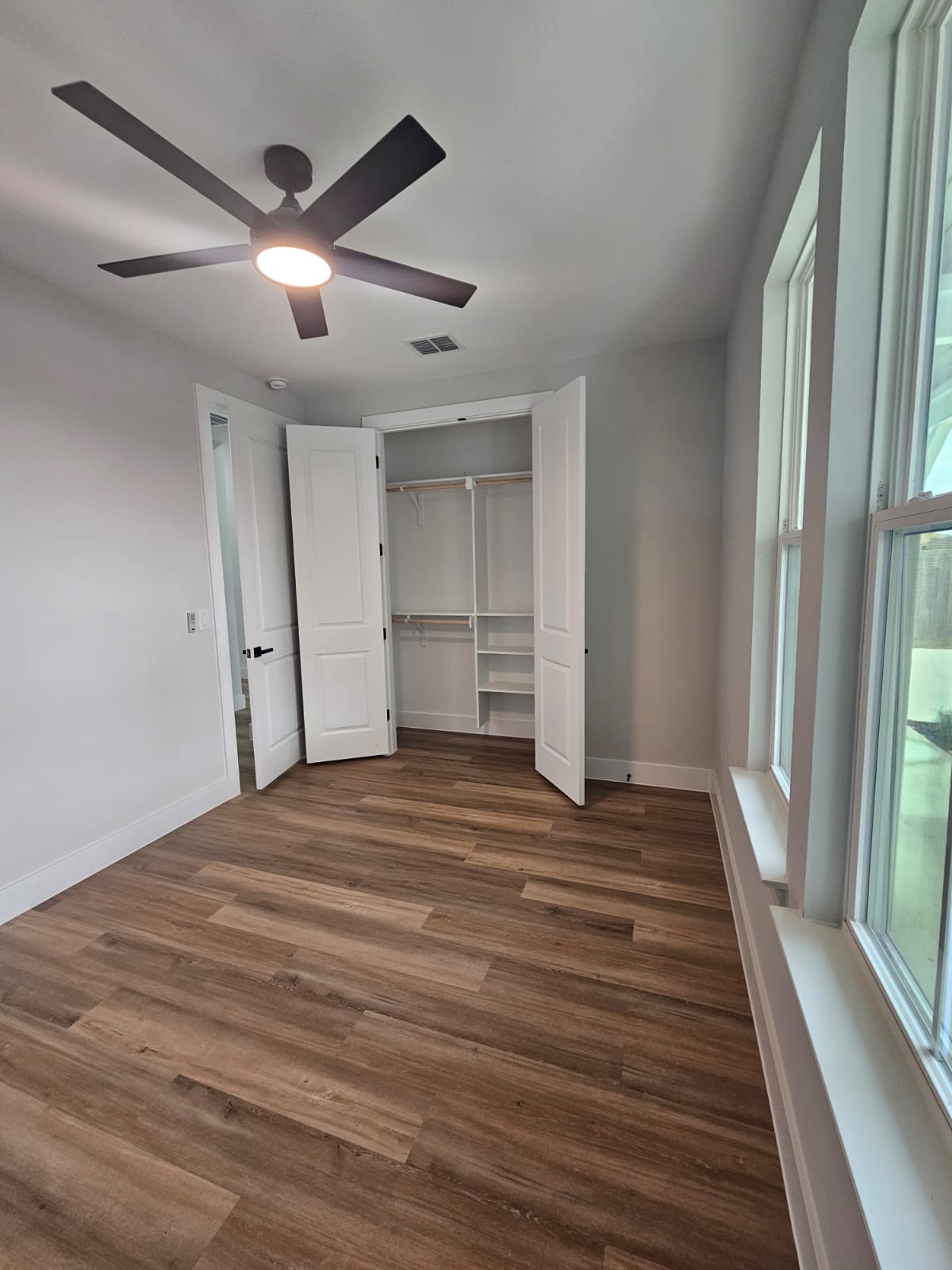 2413 Blue Sky Lane Lockhart, TX 78644 - Photo 32 of 39 Unfurnished bedroom with a ceiling fan, wood finished floors, and a closet