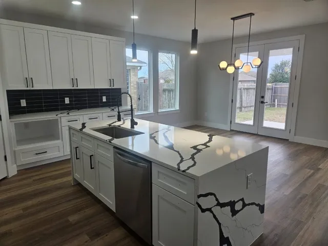 a kitchen with kitchen island a sink stainless steel appliances and cabinets