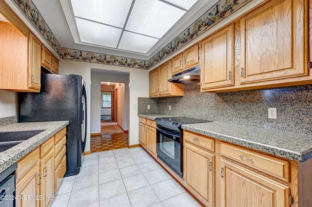 a kitchen with stainless steel appliances granite countertop a sink a stove and cabinets