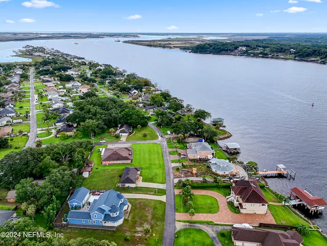 an aerial view of lake and residential houses with outdoor space