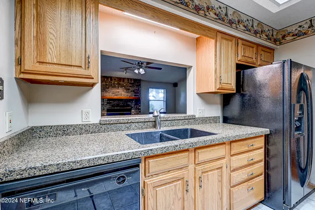 a kitchen with granite countertop stainless steel appliances a sink and cabinets