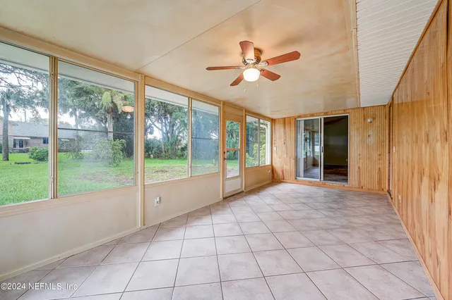 a view of an empty room and window ceiling fan