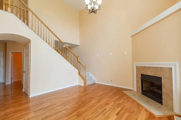 a view of empty room with wooden floor and a fireplace