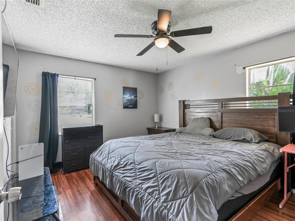 911 Jacaranda Drive Lady Lake, FL 32159 - Photo 11 of 24 a bedroom with a bed and wooden floor