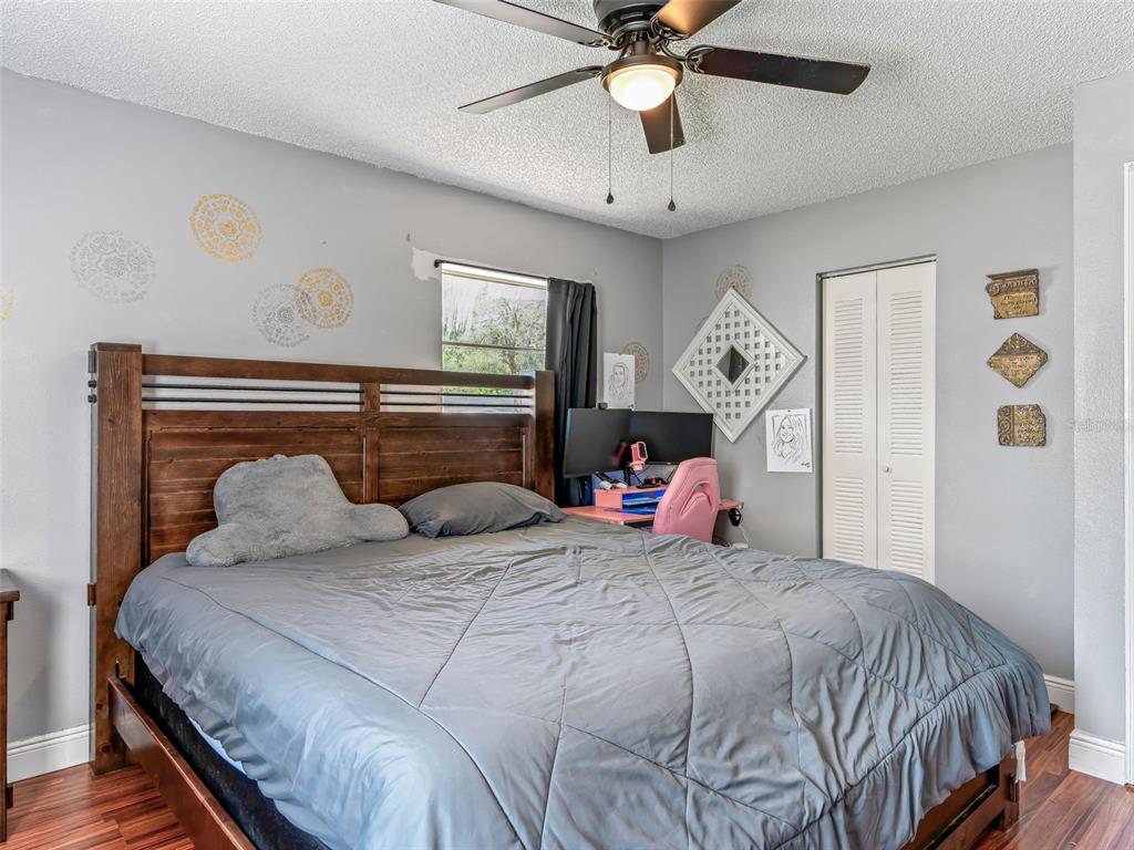 911 Jacaranda Drive Lady Lake, FL 32159 - Photo 12 of 24 a bedroom with a large bed and a chandelier