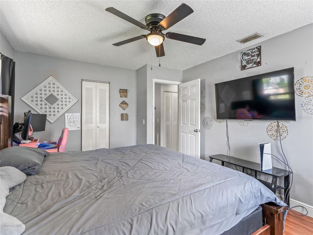 911 Jacaranda Drive Lady Lake, FL 32159 - Photo 13 of 24 a bedroom with a bed tv and a chandelier