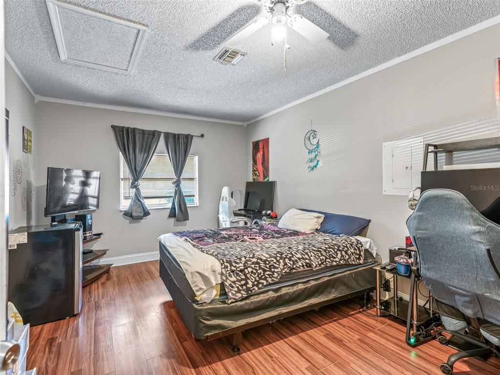 911 Jacaranda Drive Lady Lake, FL 32159 - Photo 15 of 24 a bedroom with a bed and wooden floor