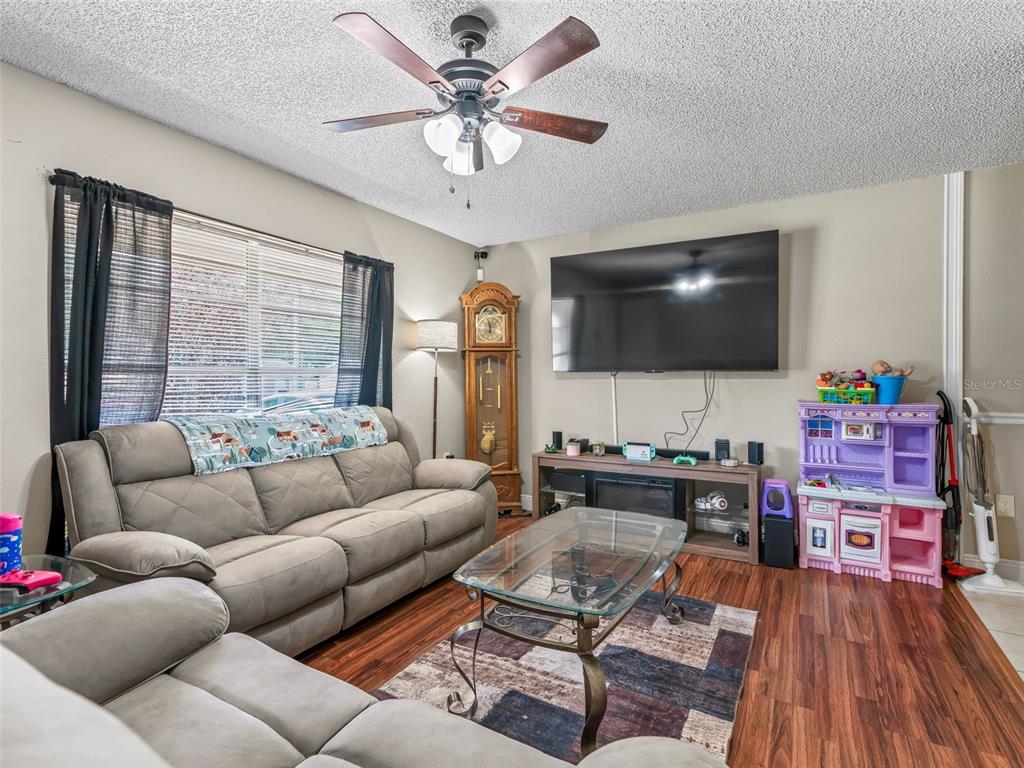 911 Jacaranda Drive Lady Lake, FL 32159 - Photo 2 of 24 a living room with furniture a flat screen tv and a large window
