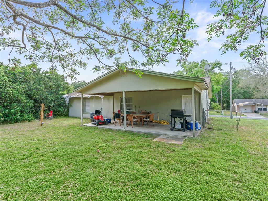 911 Jacaranda Drive Lady Lake, FL 32159 - Photo 22 of 24 a view of a house with backyard and sitting area
