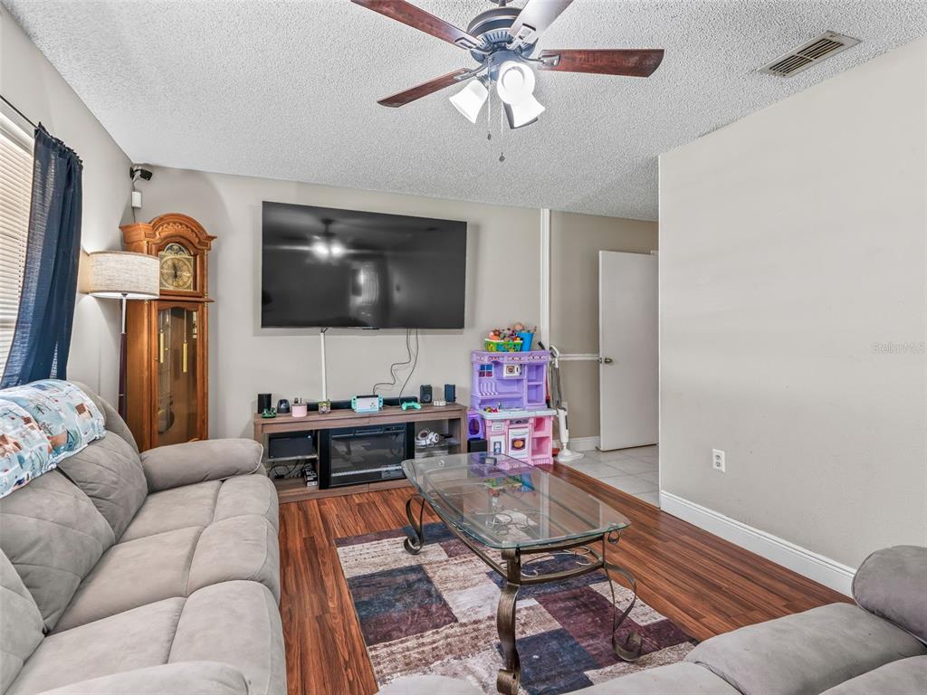 911 Jacaranda Drive Lady Lake, FL 32159 - Photo 3 of 24 a living room with furniture and a flat screen tv