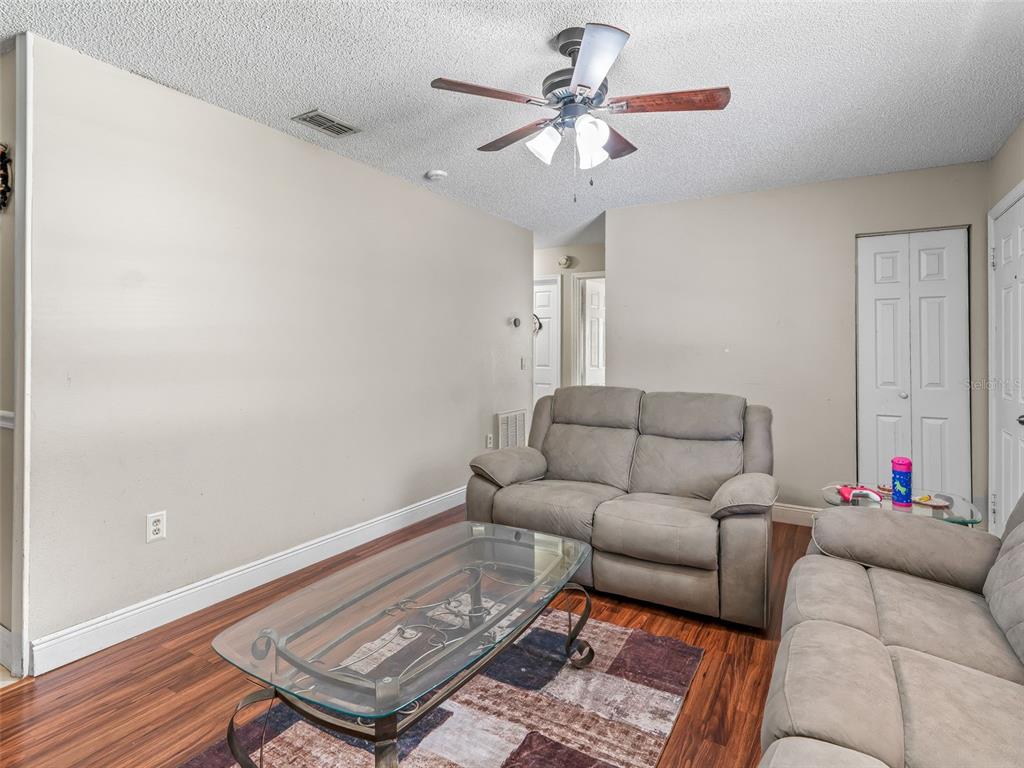 911 Jacaranda Drive Lady Lake, FL 32159 - Photo 4 of 24 a living room with furniture and a ceiling fan