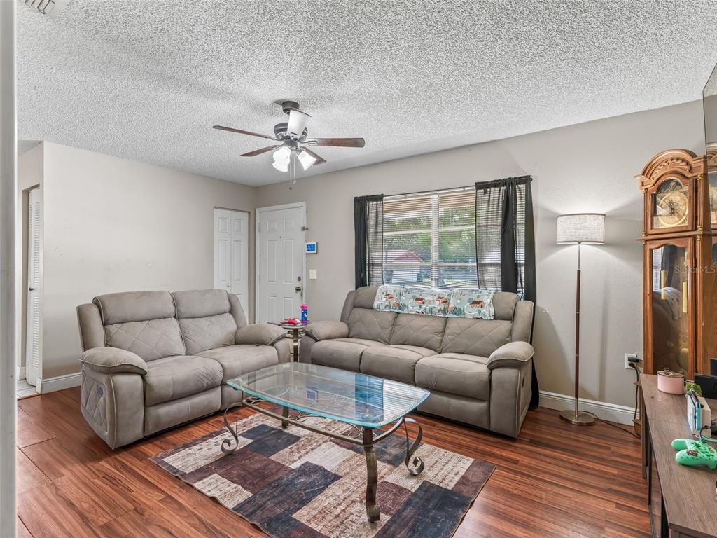 911 Jacaranda Drive Lady Lake, FL 32159 - Photo 5 of 24 a living room with furniture a ceiling fan a rug and a window