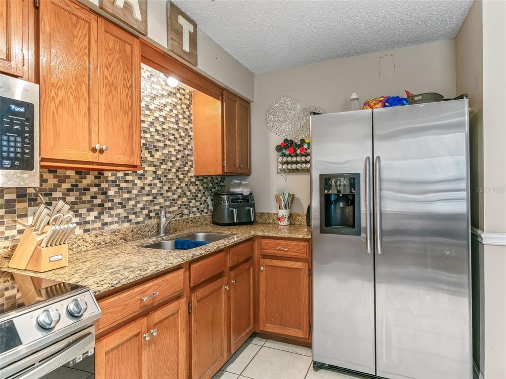 911 Jacaranda Drive Lady Lake, FL 32159 - Photo 9 of 24 a kitchen with a refrigerator and a sink