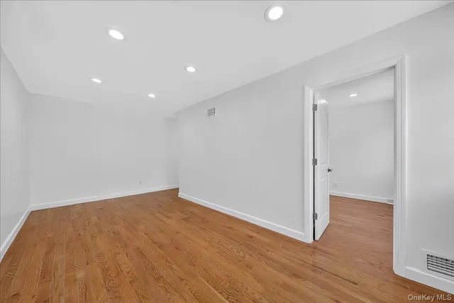 an empty room with wooden floor and entrance
