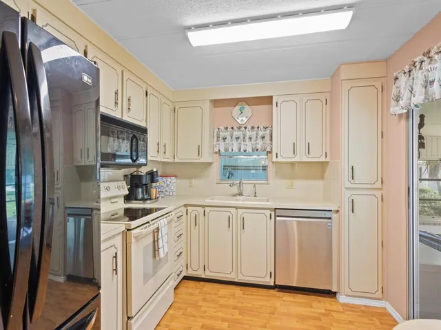 a kitchen with cabinets stainless steel appliances and a window