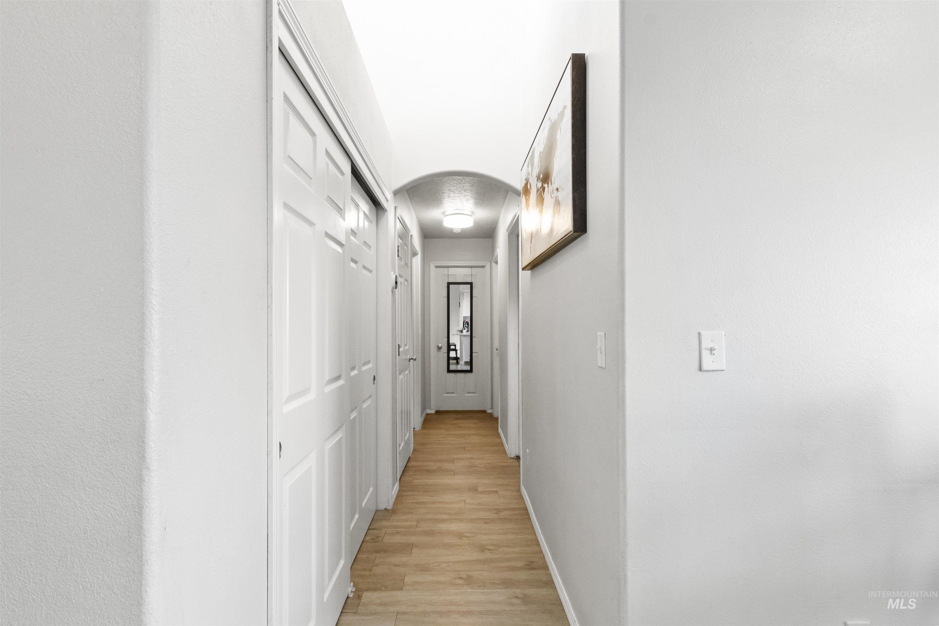 1823 Cambridge Street Caldwell, ID 83607 - Photo 3 of 10 Hallway with arched walkways and light wood finished floors