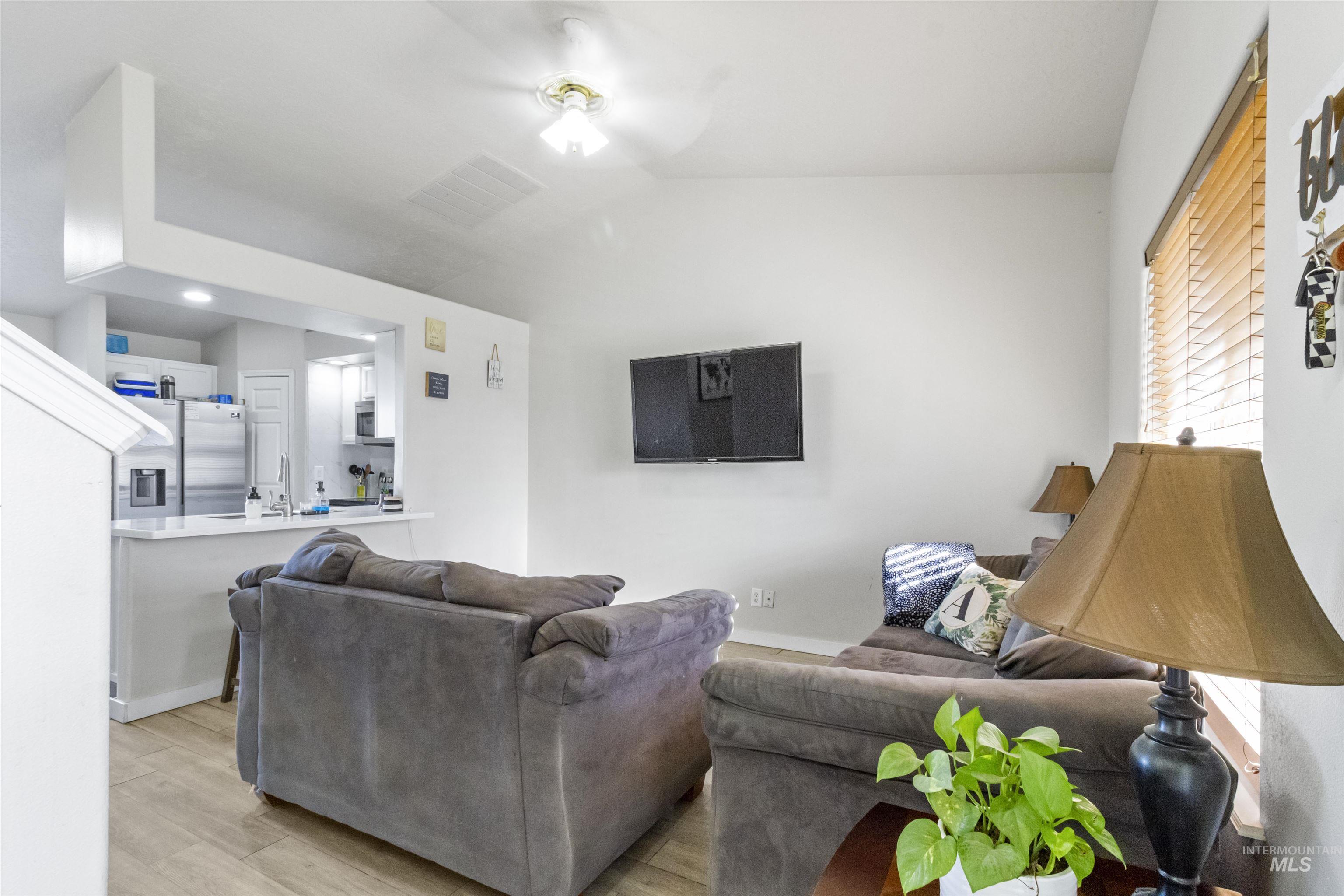 1823 Cambridge Street Caldwell, ID 83607 - Photo 6 of 10 Living area with light wood-style floors, vaulted ceiling, and a ceiling fan